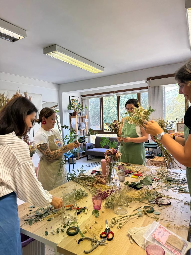 Hands wrapping dried flowers bouquet learning sustainable floral preservation techniques Porto