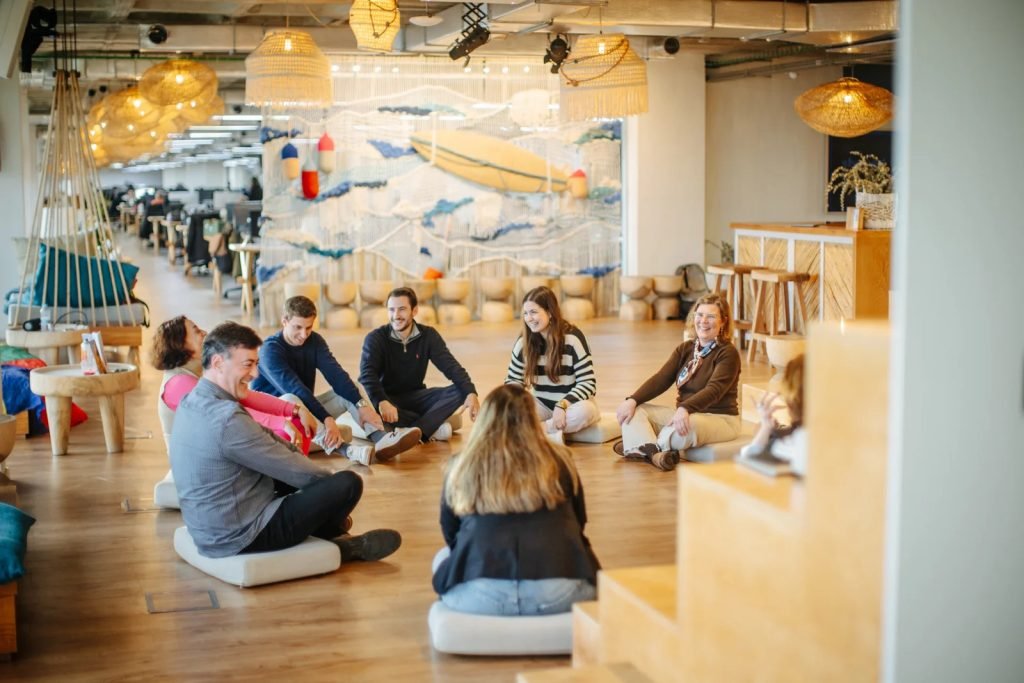 People laughing together during laughter yoga session building instant friendships through shared experience Lisbon