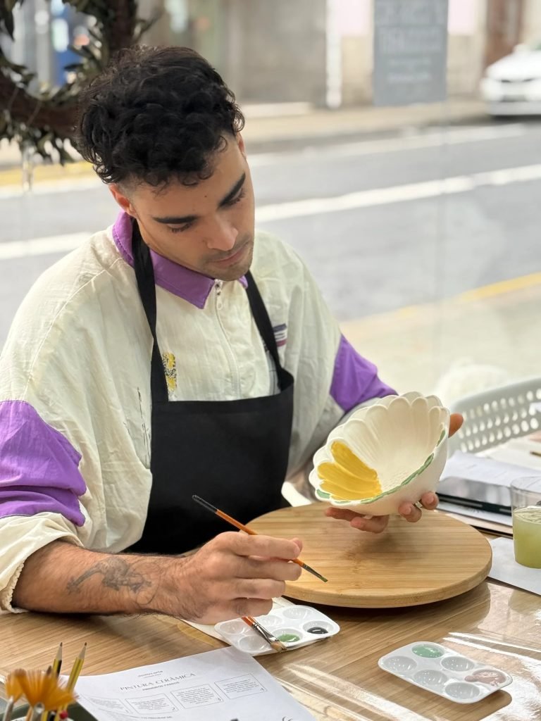 Beginner painting ceramic bowl at own pace during Domus Arte pottery workshop downtown Porto