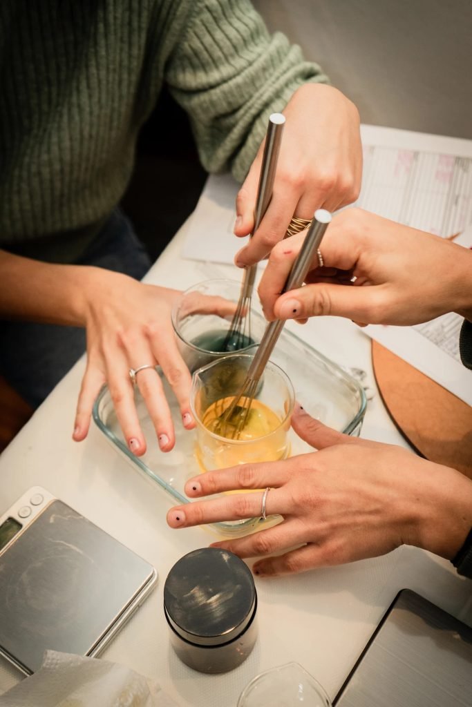Woman formulating personalized natural body butter with plant-based ingredients in Lisbon skincare workshop