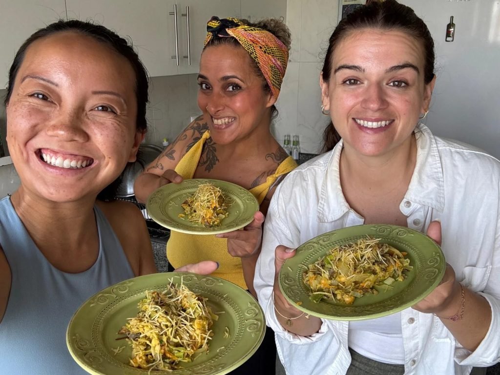 Group enjoying communal vegan Portuguese meal with wine after cooking class workshop Porto
