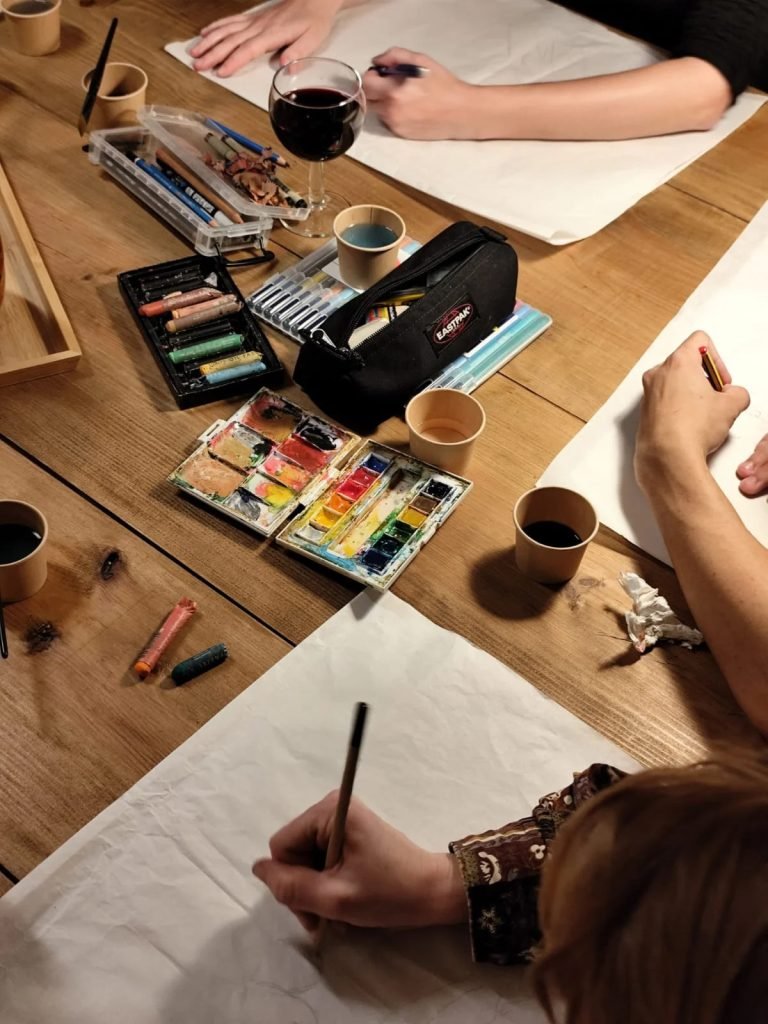 Artists socializing with wine while drawing live model during Art and Sip workshop making friends Lisbon